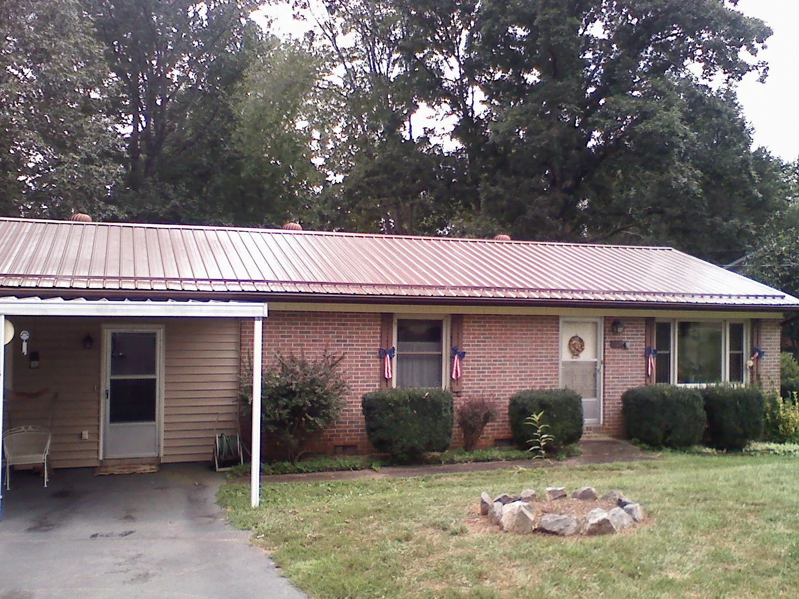 Bronze metal roof and carport on a brick ranch home — Roof Repair work by our crew in Cornelius